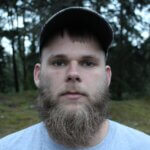 man in gray crew neck shirt wearing black cap